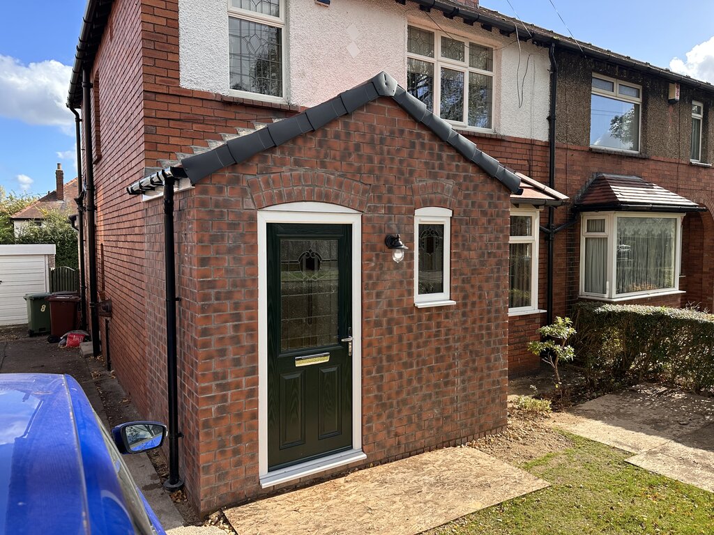 Completed brick porch extension with pitched roof, decorative brick arches and composite front door by CG Building Services.